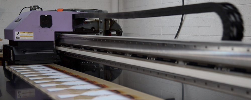 Mimaki flatbed UV printer printing on acrylic sheet stock.